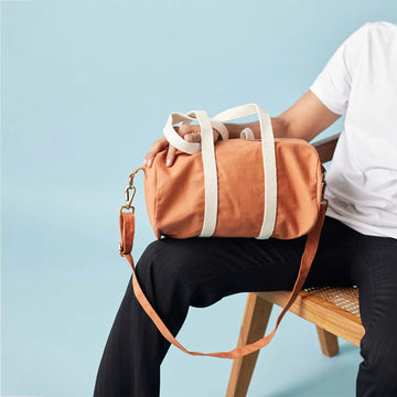 Browse our classic travel companion, a duffle bag for women available in rust colour in small size
