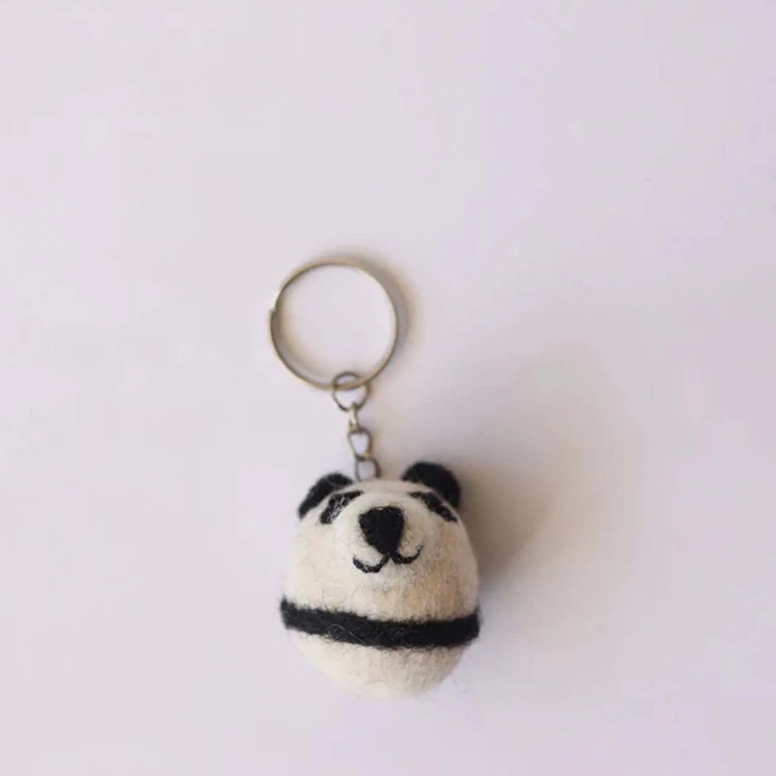 Cute pocket sized panda plush with black and white fur small ears and a friendly expression perfect for carrying around
