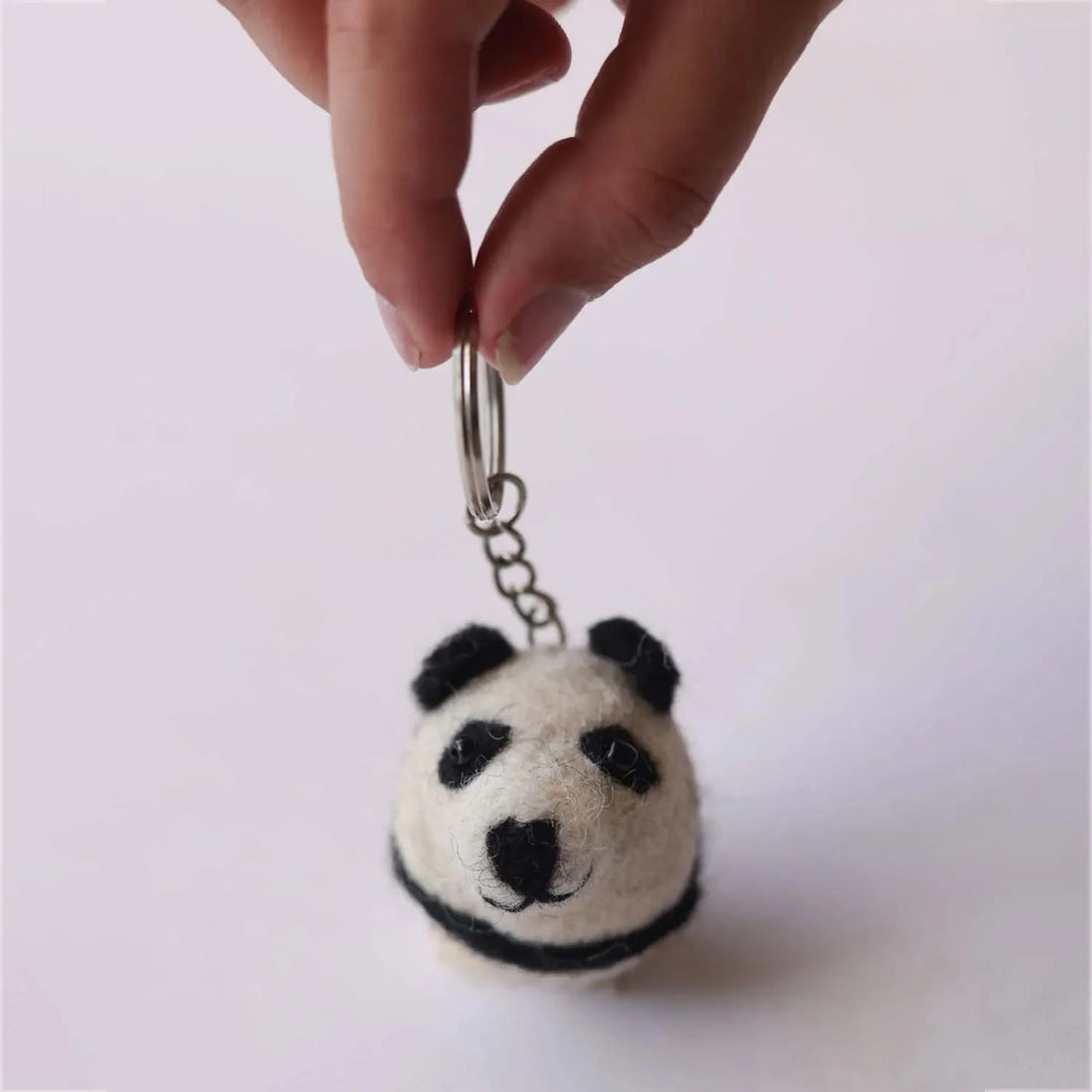 Cute pocket sized panda plush with black and white fur small ears and a friendly expression perfect for carrying around
